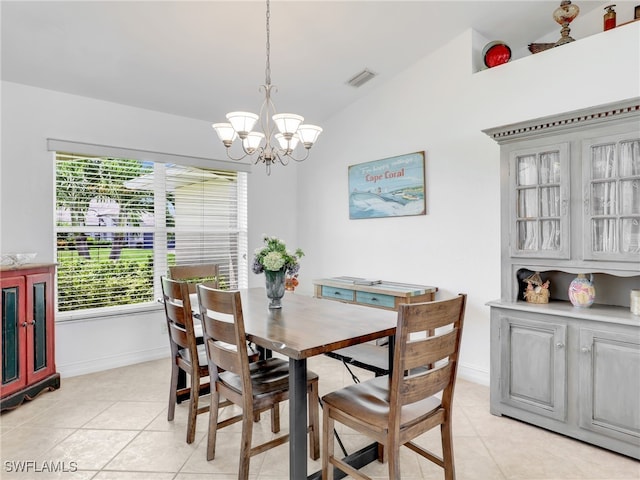 dining area featuring lofted ceiling, light tile patterned flooring, and a notable chandelier