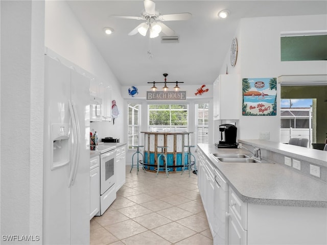 kitchen with lofted ceiling, white appliances, white cabinetry, and ceiling fan