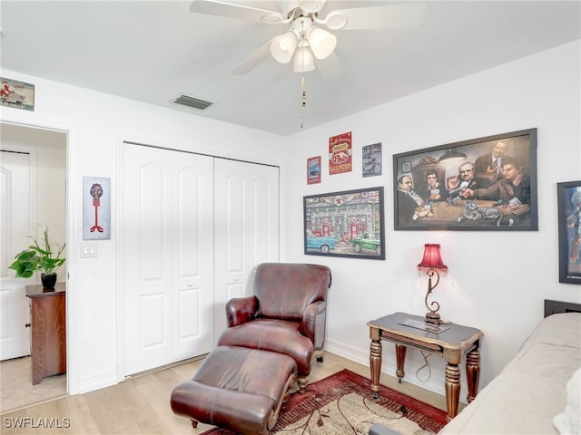 living area with light wood-type flooring and ceiling fan