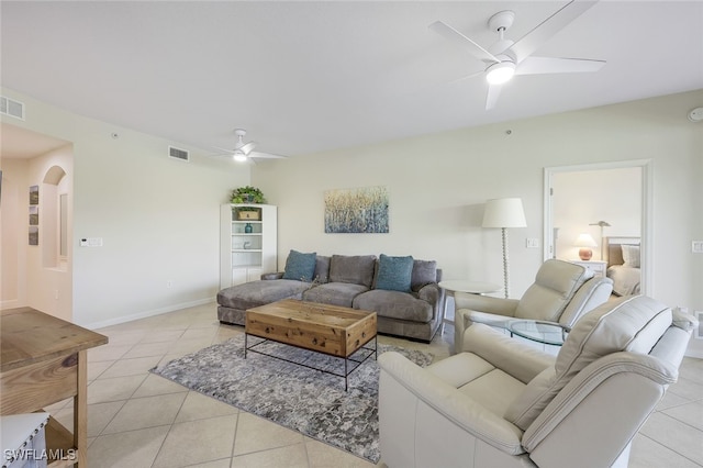 living room with light tile patterned floors, visible vents, arched walkways, and a ceiling fan