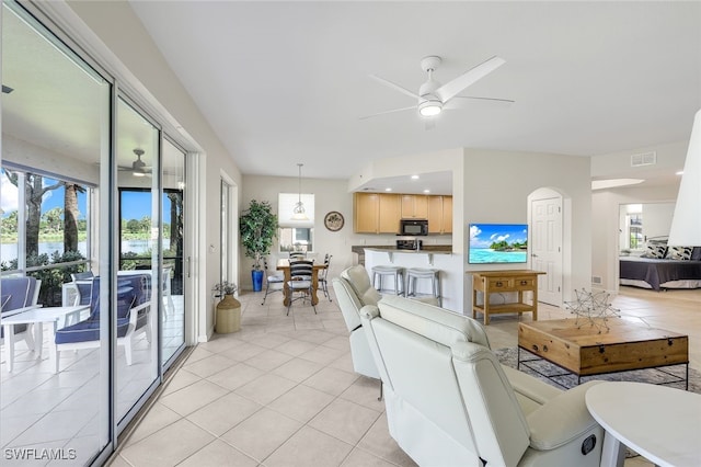 living room with a ceiling fan, a healthy amount of sunlight, and visible vents