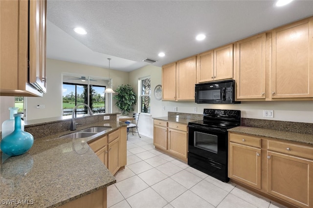 kitchen with dark stone counters, black appliances, light brown cabinetry, and a sink