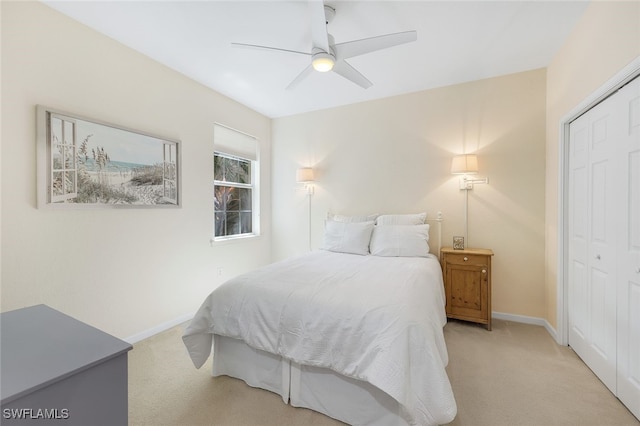 bedroom with light carpet, a closet, and baseboards