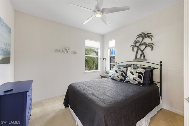 bedroom with ceiling fan, baseboards, and light colored carpet