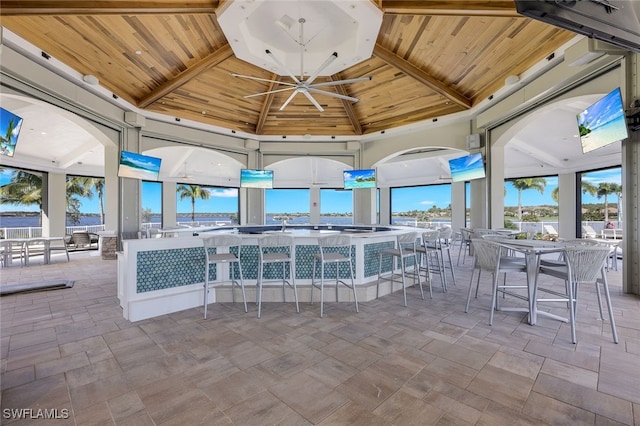 interior space with ceiling fan, a bar, and a gazebo