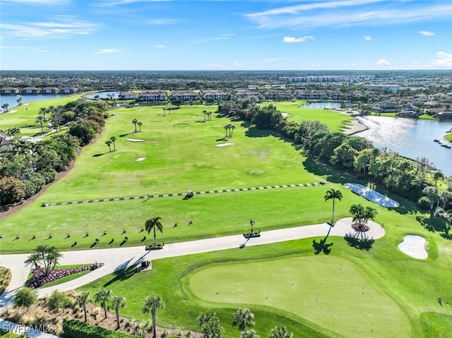 birds eye view of property with view of golf course and a water view