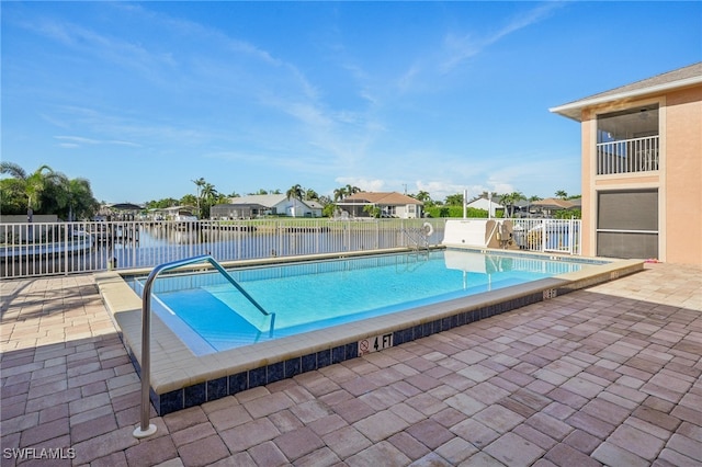 view of swimming pool featuring a water view and a patio