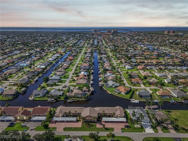 aerial view at dusk featuring a water view