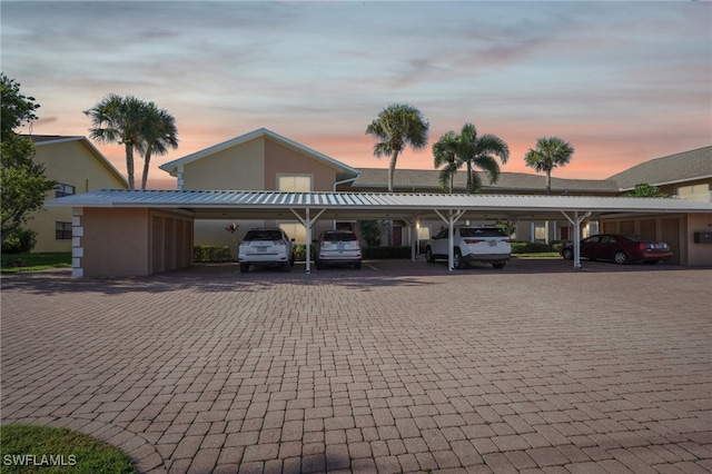 parking at dusk featuring a carport