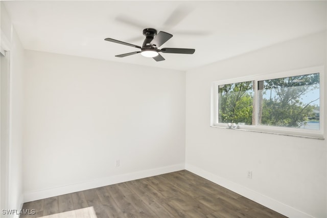 spare room with dark hardwood / wood-style flooring and ceiling fan