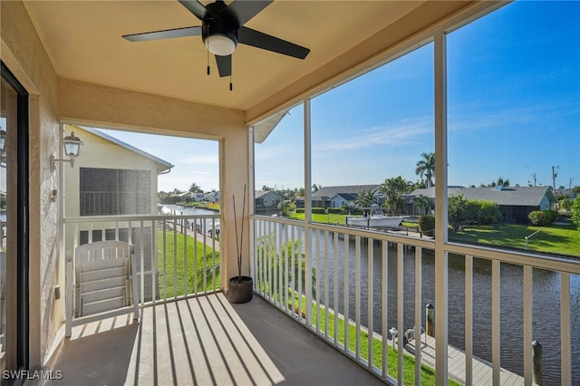 balcony featuring a water view and ceiling fan