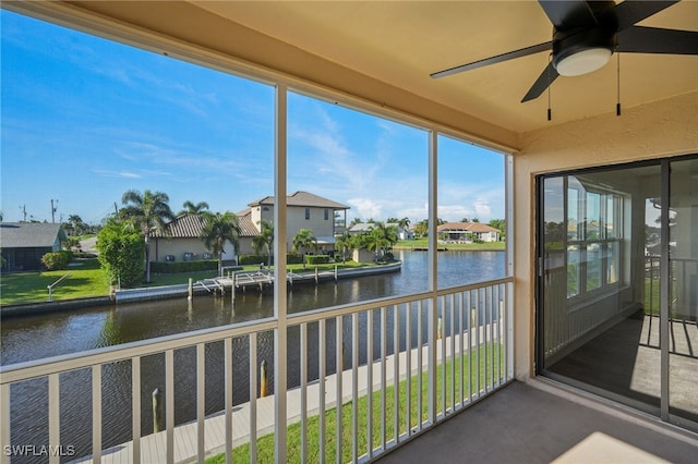 sunroom featuring a water view and ceiling fan