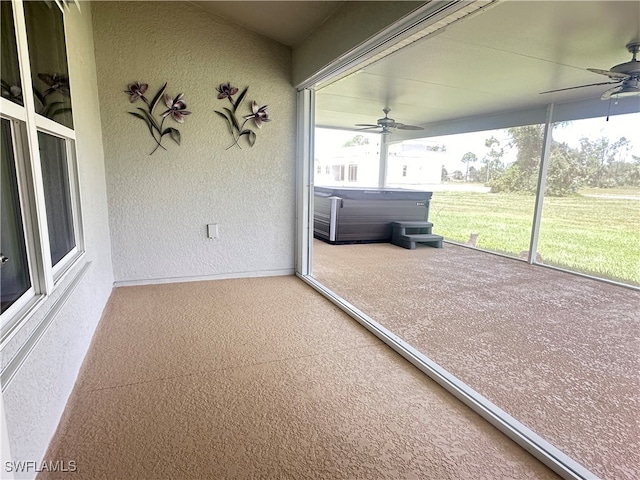 unfurnished sunroom with ceiling fan