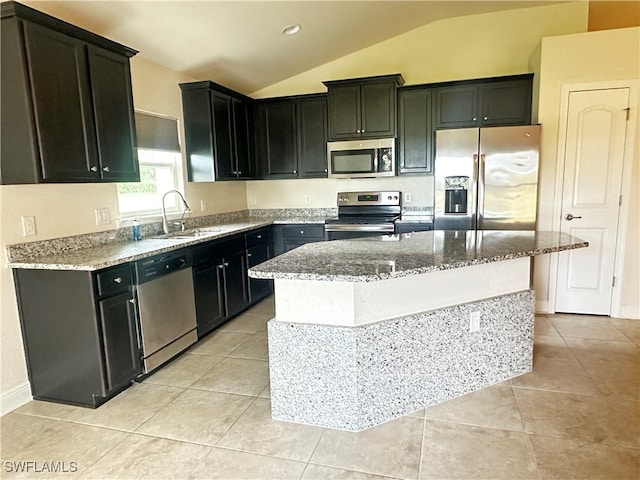 kitchen with a kitchen island with sink, stone counters, stainless steel appliances, sink, and lofted ceiling