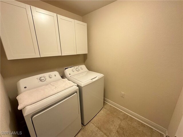 laundry area with independent washer and dryer, cabinets, and light tile patterned floors