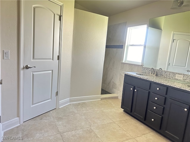 bathroom with tile patterned floors, walk in shower, and vanity