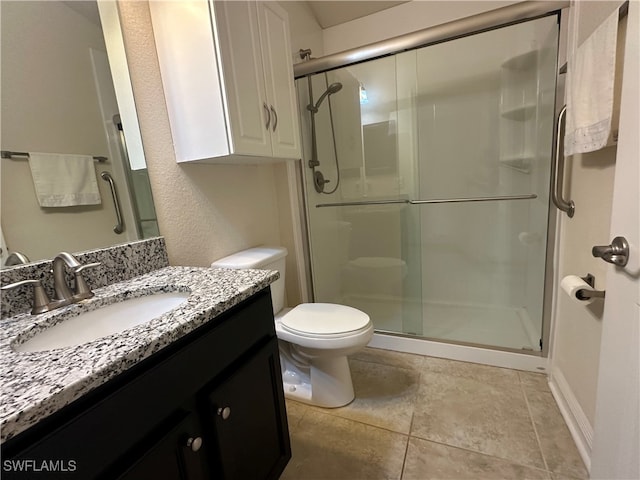 bathroom featuring a shower with door, vanity, toilet, and tile patterned flooring