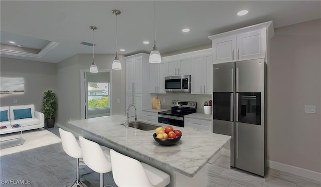 kitchen with a center island with sink, appliances with stainless steel finishes, and white cabinetry