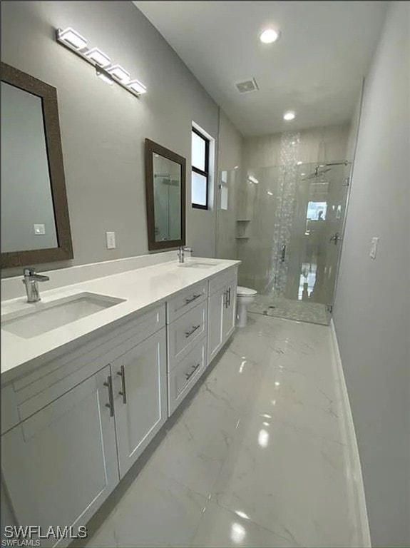 bathroom with a shower with door, vanity, and toilet