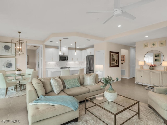 living room featuring ceiling fan with notable chandelier