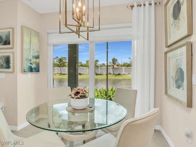 dining area with a water view, light tile patterned flooring, and an inviting chandelier