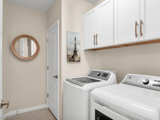 washroom featuring cabinets, light tile patterned floors, and separate washer and dryer