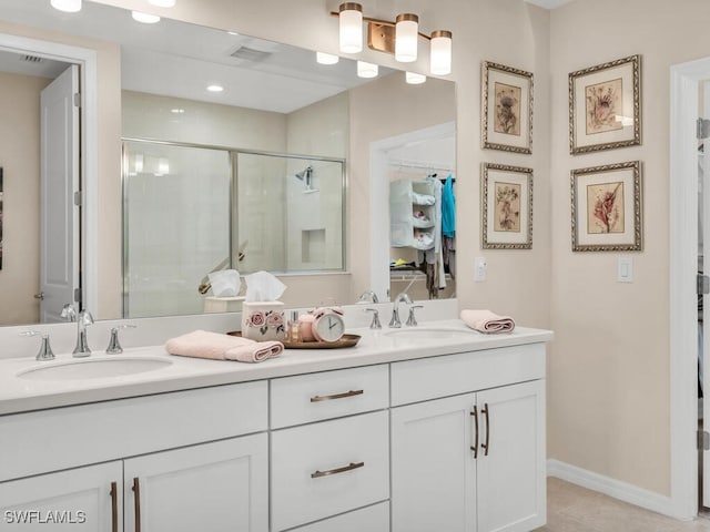 bathroom with tile patterned floors, vanity, and an enclosed shower