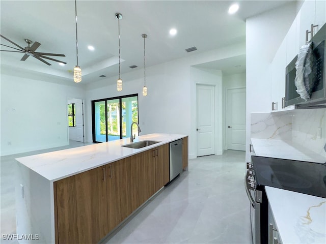 kitchen with pendant lighting, stainless steel appliances, a tray ceiling, white cabinetry, and sink