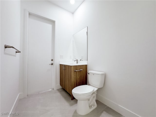 bathroom featuring toilet, vanity, and tile patterned flooring