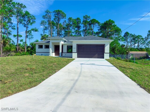 view of front of property with a front yard and a garage