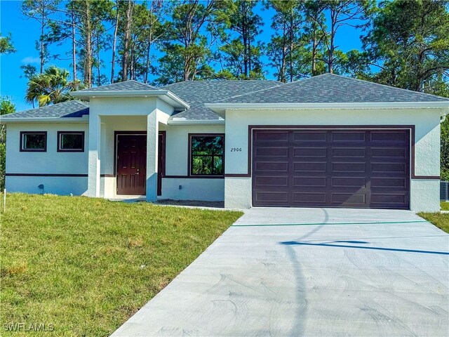 view of front of house with a front yard and a garage