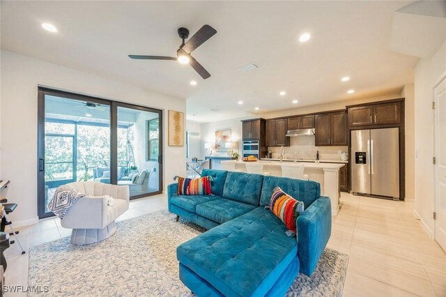 tiled living room featuring ceiling fan and sink