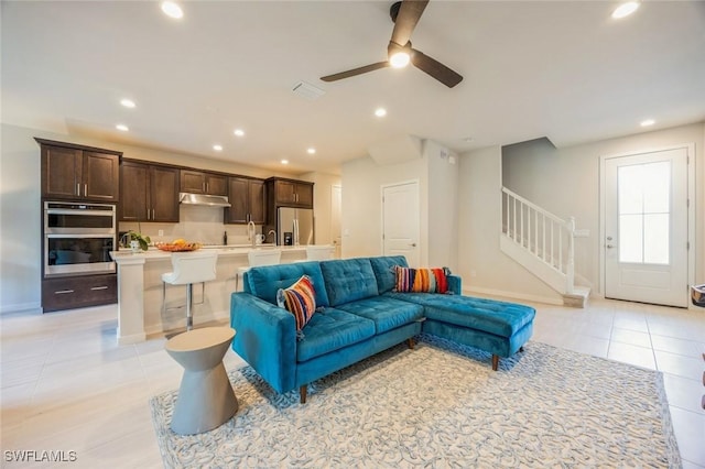 living area featuring stairway, light tile patterned floors, visible vents, baseboards, and recessed lighting