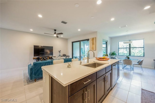 kitchen with a center island with sink, visible vents, a sink, light countertops, and dishwasher