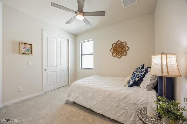 bedroom featuring visible vents, baseboards, ceiling fan, carpet flooring, and a closet