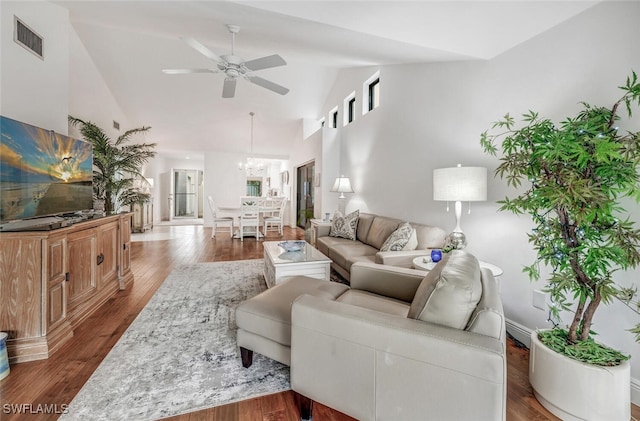 living room featuring visible vents, ceiling fan with notable chandelier, high vaulted ceiling, and wood finished floors