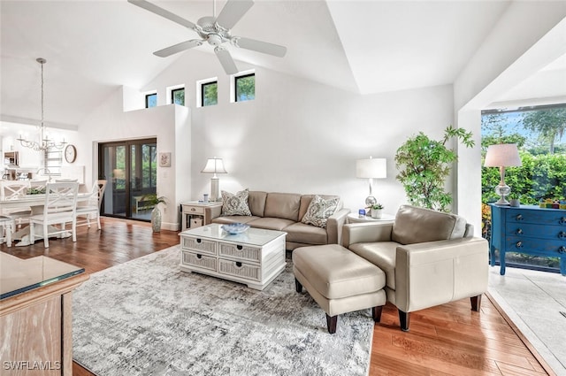 living area featuring plenty of natural light, wood finished floors, and ceiling fan with notable chandelier