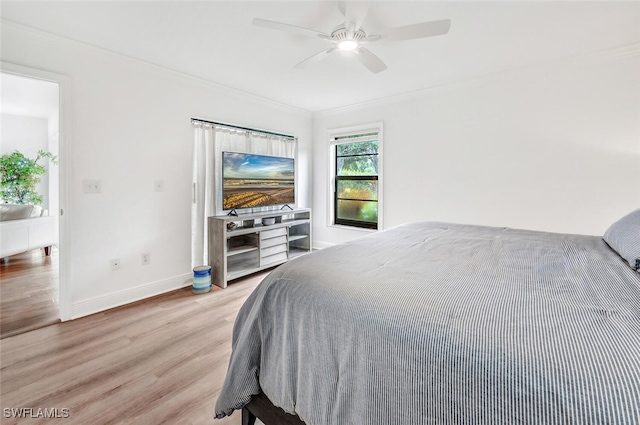 bedroom featuring baseboards, light wood-style floors, ceiling fan, and crown molding