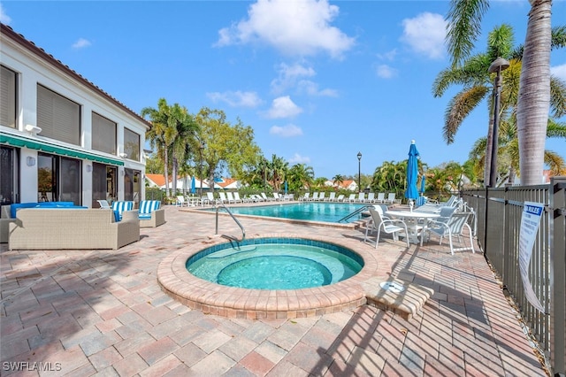 community pool with a patio, fence, a community hot tub, and an outdoor living space