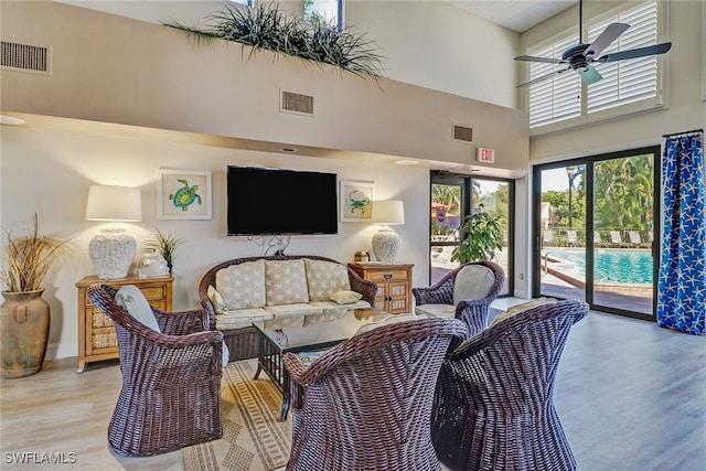 living room with visible vents, ceiling fan, and light wood finished floors