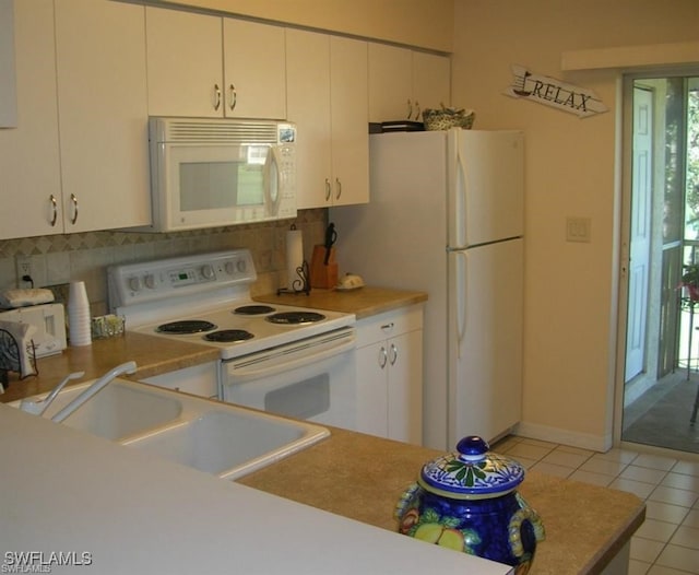 kitchen featuring white appliances, sink, decorative backsplash, white cabinets, and light tile patterned flooring