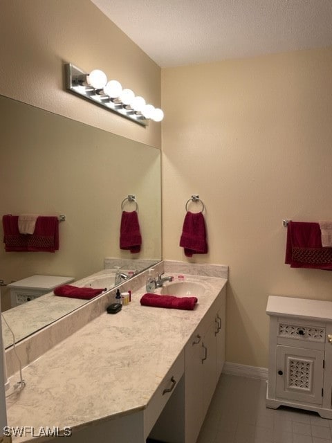 bathroom featuring a textured ceiling, vanity, and toilet