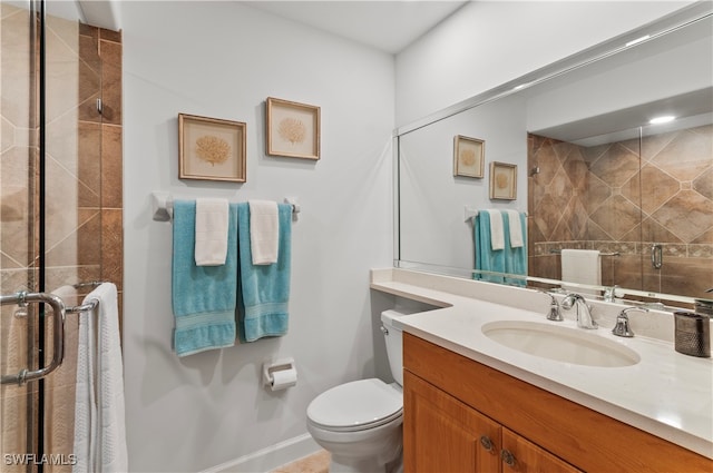 bathroom with a shower with shower door, toilet, and vanity