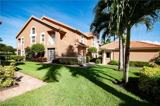 exterior space featuring a balcony and a lawn