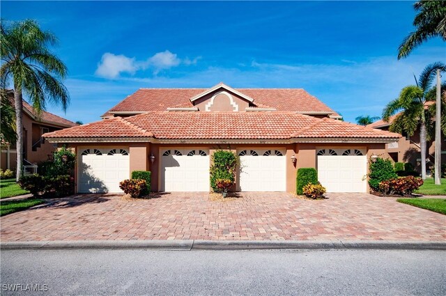 13256 Sherburne Cir Unit 2601, Bonita Springs, FL 34135 - view of front of property featuring stucco siding, a tile roof, and a garage