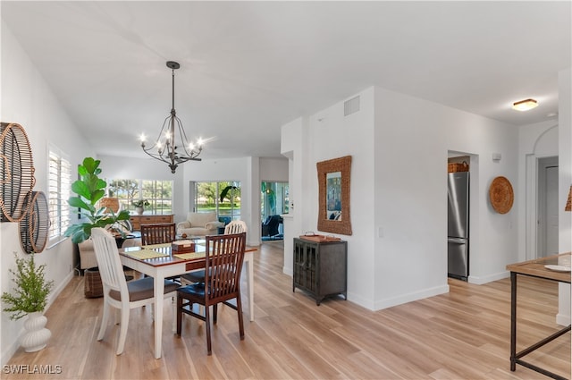 dining area featuring light hardwood / wood-style flooring and an inviting chandelier