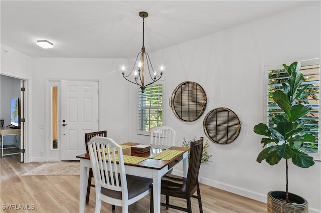 dining space featuring an inviting chandelier and light hardwood / wood-style flooring