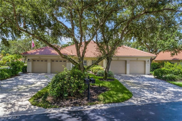 view of front facade with a tiled roof, an attached garage, and stucco siding