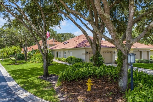 view of front of home with a garage, stucco siding, a tiled roof, and a front yard