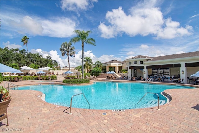 pool featuring a hot tub and a patio